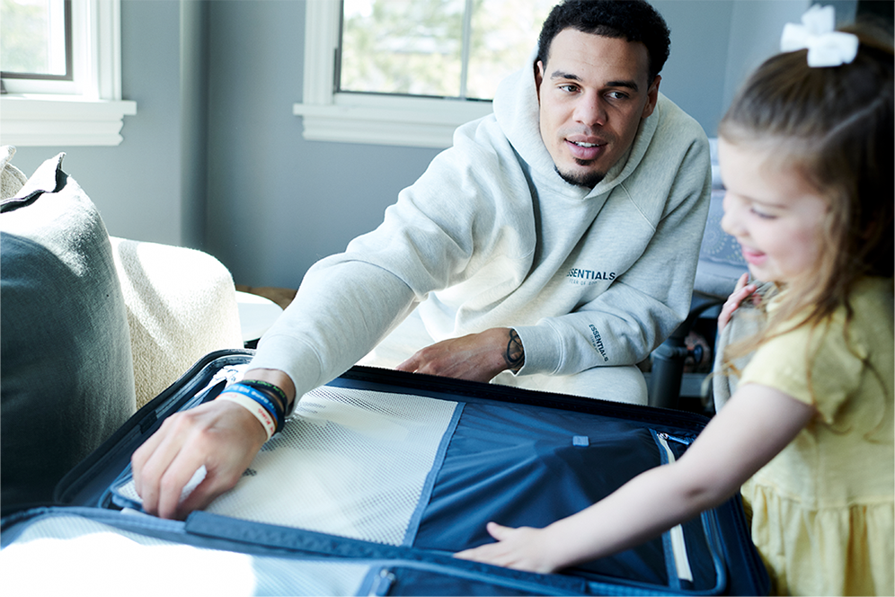NFL Player Justin Simmons opening suitcase with his daughter